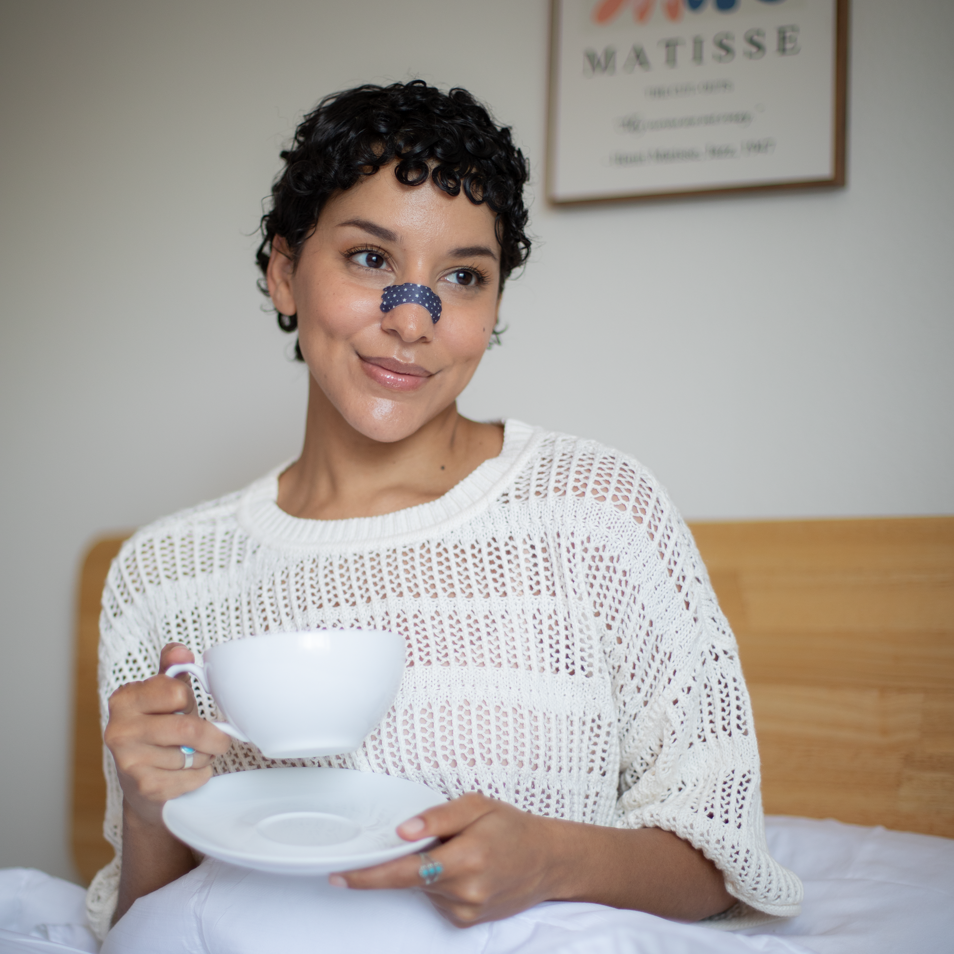 Girl having her morning coffee in bed wearing her Starry Night Breezys Nasal Strip